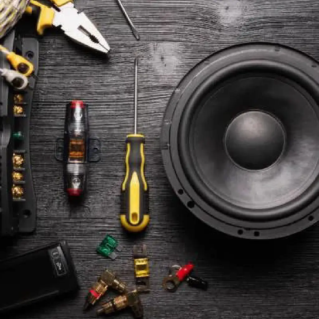 Technician performing safe car amplifier and subwoofer wiring at the best car audio shop in Dubai with proper grounding and factory integration